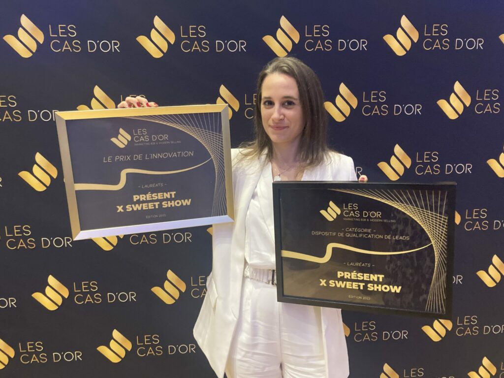 Noémie Lecorps tenant deux trophées aux Cas d'Or pour le projet Présent x Sweet Show